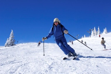 woman skiing on ski slope with blue sky