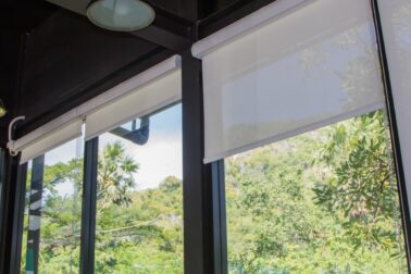 white roller blinds or curtains at the glass window