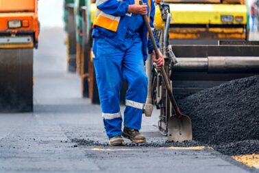 Close view on the workers and the asphalting machines