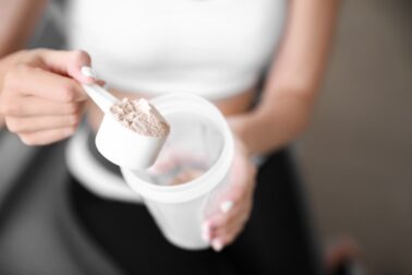 Sporty young woman with protein at home, closeup