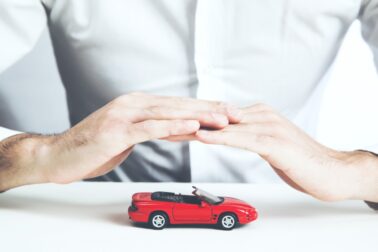 Car insurance concept. Man and model of car  on table