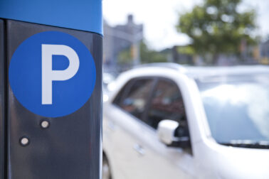 A blue parking ticket machine beside the road
